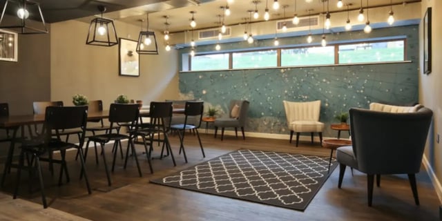 Dining table chairs patterned rug and armchairs lounge at One & Two Victoria Point in Manchester Student Accommodation