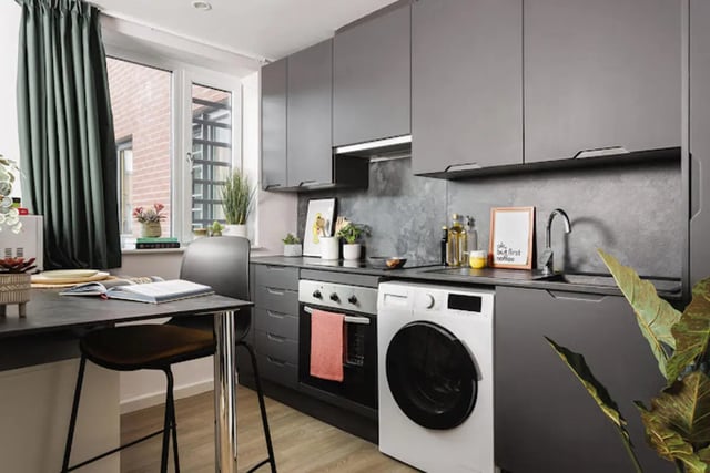 Counter table chair oven washing machine sink kitchen at Kincardine Court in Manchester Student Accommodation