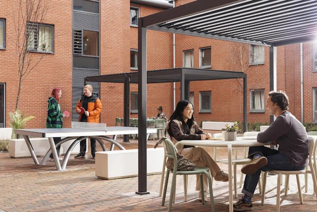 People playing ping pong and sitting at tables outdoor area at Kincardine Court in Manchester Student Accommodation