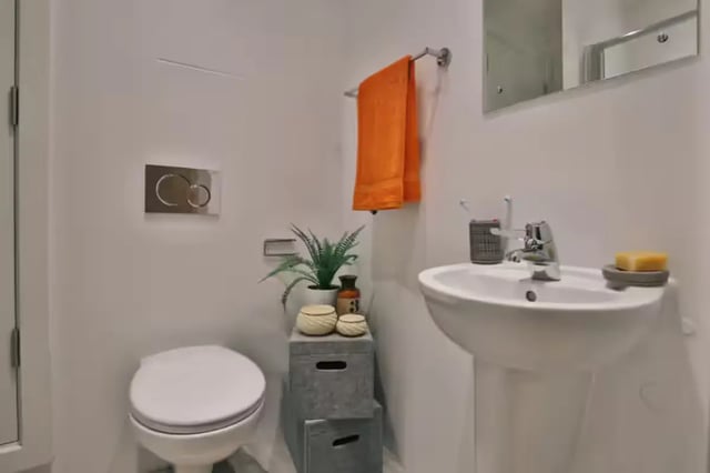 Toilet sink orange towel plant soap bathroom at The Frontage in Nottingham Student Accommodation