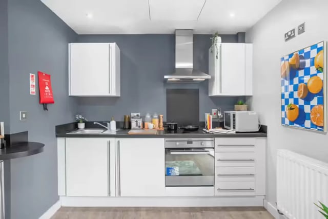 White cabinets sink toaster microwave and artwork kitchen at Alwyn Court in Cardiff Student Accommodation
