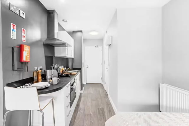 Kitchen area with a white bar stool and cabinetry Kitchen area at Northgate House Apartments in Cardiff Student Accommodation