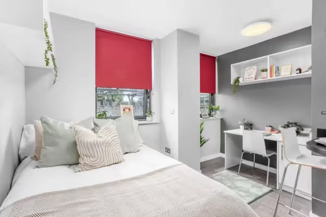 Bed with cushions desk with chairs shelving bedroom at Northgate House Apartments in Cardiff Student Accommodation
