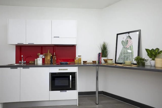 White cabinets microwave sink red backsplash kitchen at Athena Studios in Birmingham Student Accommodation
