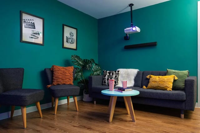 Sofa chairs coffee table projector pictures living room at Tramworks in Glasgow Student Accommodation
