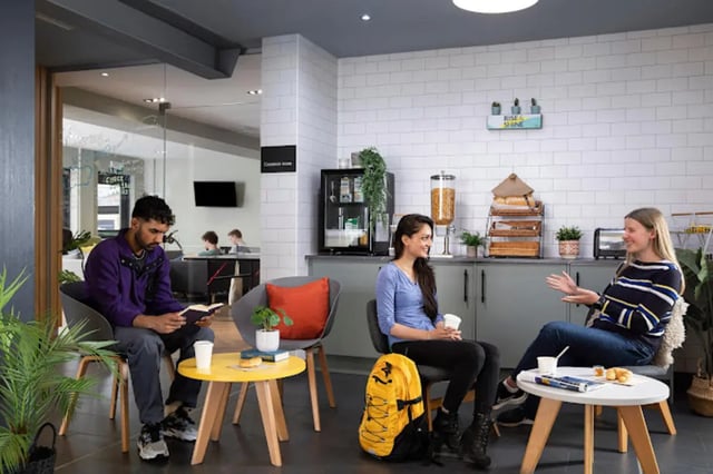 Students relax and converse in a common room. at Tramworks in Glasgow Student Accommodation