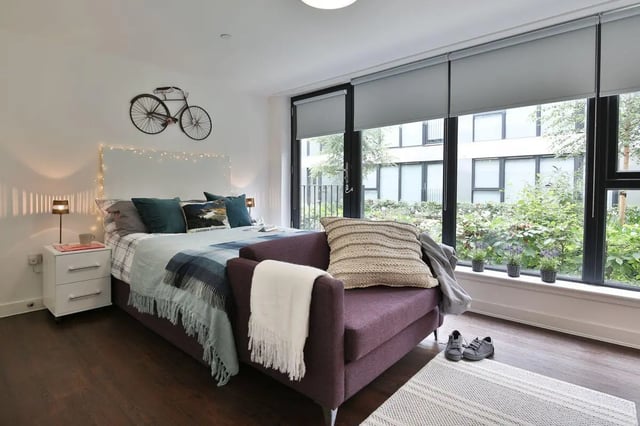 Bed sofa bedside table bicycle decor bedroom at The Ballet School in Glasgow Student Accommodation