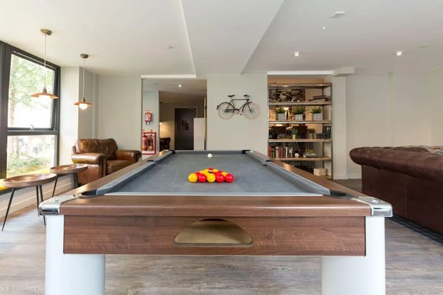 Pool table with balls chairs and shelves communal area at The Ballet School in Glasgow Student Accommodation