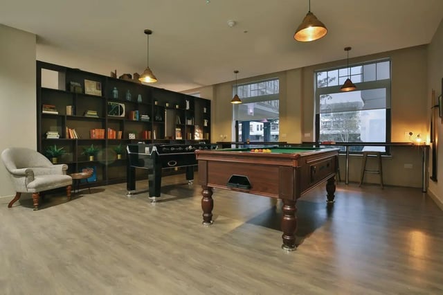 Pool and foosball tables armchair bookshelves leisure room at Bath Street in Glasgow Student Accommodation