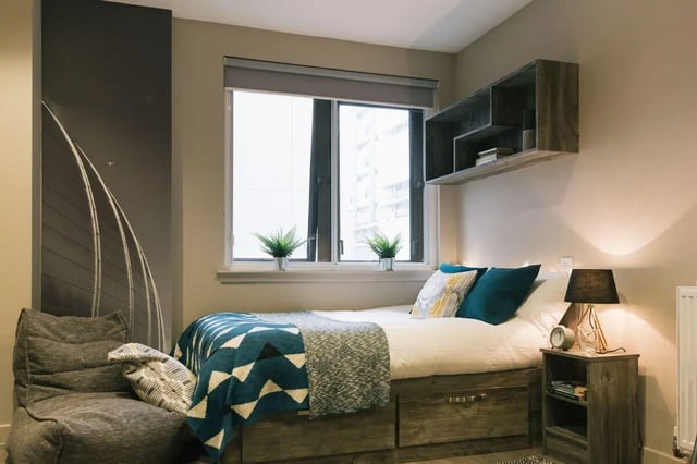 Bed with blue blanket shelf nightstand Bedroom at Bath Street in Glasgow Student Accommodation