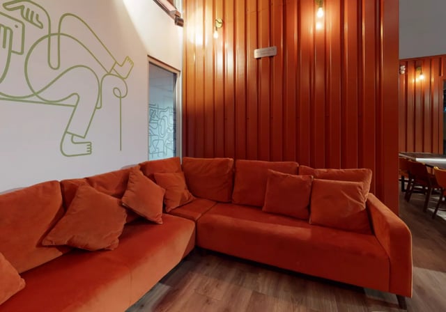 Orange sectional sofa with pillows living room at iQ Elgin Place in Glasgow Student Accommodation