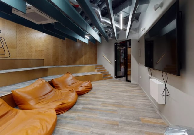 Orange bean bags tiered seating wall mounted TV lounge at iQ Elgin Place in Glasgow Student Accommodation