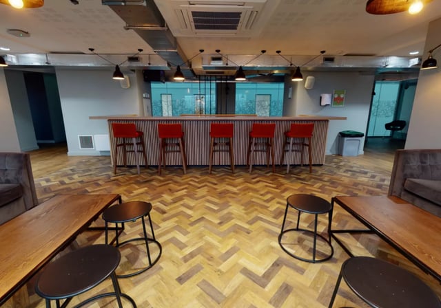 Bar with red stools wooden floor common area at iQ Elgin Place in Glasgow Student Accommodation