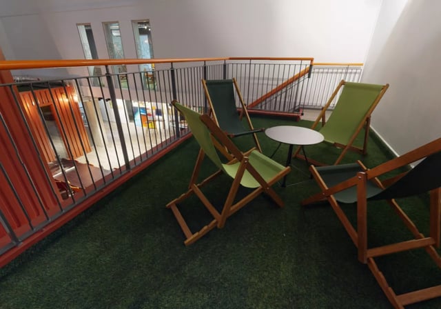 Deck chairs and table on artificial grass area at iQ Elgin Place in Glasgow Student Accommodation