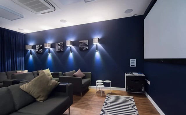 Dark sofas and movie screen living room at Clifton & Stewart House in Glasgow Student Accommodation