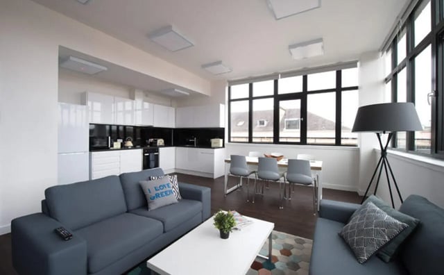 Modern open plan living room with sofa kitchen dining area living room at Clifton & Stewart House in Glasgow Student Accommodation