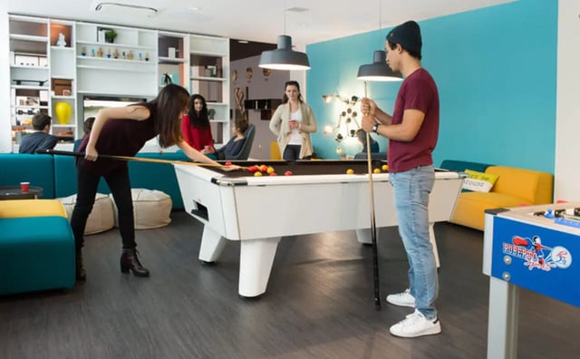 Students playing pool and foosball common area living room at Clifton & Stewart House in Glasgow Student Accommodation