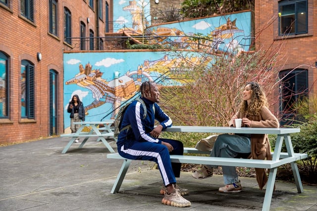 Students at picnic table mural courtyard exterior at Brunel House in Bristol Student Accommodation
