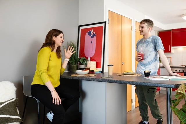 Two people at breakfast bar kitchen dining area at Phoenix Court in Bristol Student Accommodation