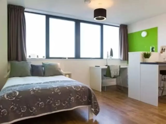 Bed desk chair and large windows bedroom at St Lawrence House in Bristol Student Accommodation