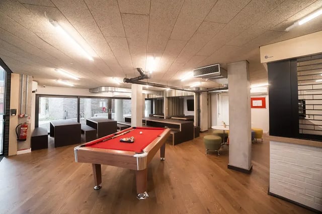 Pool table dark seating areas and green stools common area at AXO Paradise Student Village in Coventry Student Accommodation
