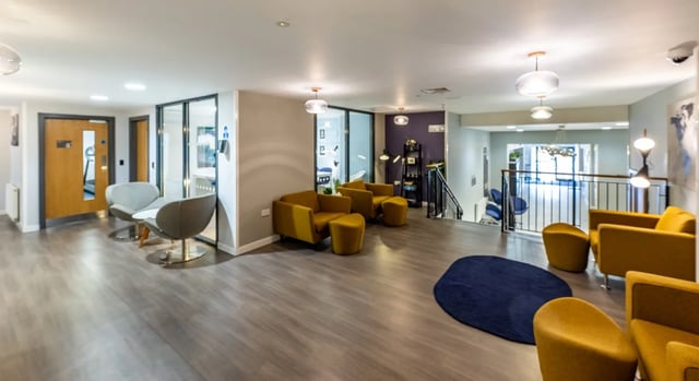Modern seating area with yellow chairs and grey seating. at Haddington Place in Edinburgh Student Accommodation