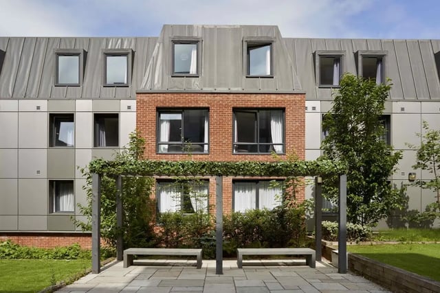 Two benches under pergola with building exterior exterior at Asa Briggs House in Leeds Student Accommodation