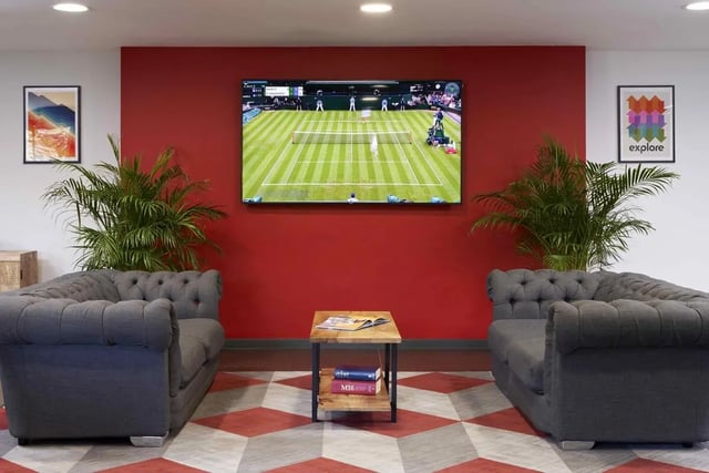 Two grey sofas a coffee table and tennis on TV living room at Asa Briggs House in Leeds Student Accommodation