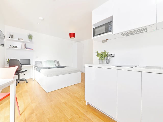 Bed desk chair microwave white cabinets kitchen bedroom at The Pavilion - Leeds in Leeds Student Accommodation