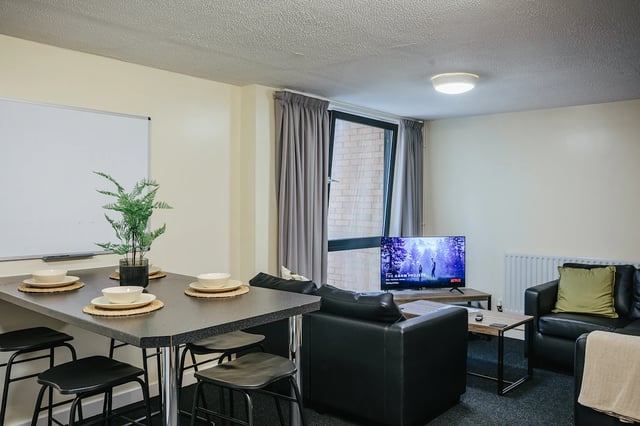 Dining table with stools and living area living room at The Pinnacles in Sheffield Student Accommodation