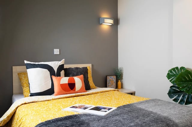 Bed with patterned quilt and pillows bedroom at Somerset Court in London Student Accommodation