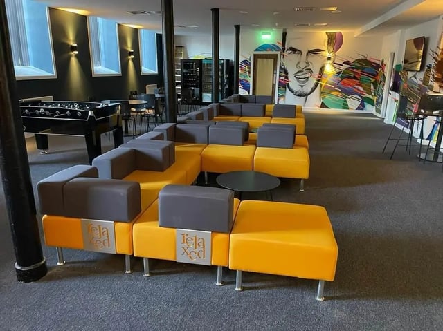 Modular orange and grey sofa with mural living room at Silk Mill Lancaster in Lancaster Student Accommodation