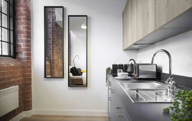 Mirrors brick wall heating kitchen counter sink toaster kitchen at Silk Mill Lancaster in Lancaster Student Accommodation