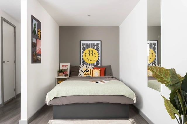 Bed with colorful pillows and wall art bedroom at Newgate Court in Newcastle Upon Tyne Student Accommodation