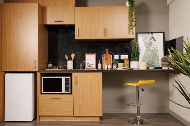 Compact kitchen with fridge microwave and yellow stool kitchen at Manor Bank in Newcastle Upon Tyne Student Accommodation