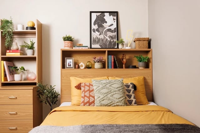 Bed with yellow bedding wooden bookshelf bedroom at Manor Bank in Newcastle Upon Tyne Student Accommodation