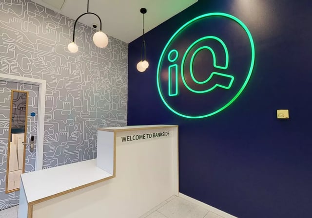 Welcome desk with IC logo and patterned wall reception at iQ Bankside in London Student Accommodation