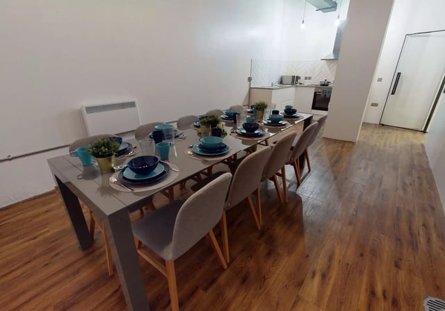 Dining table set with blue plates chairs kitchen area at iQ Bankside in London Student Accommodation