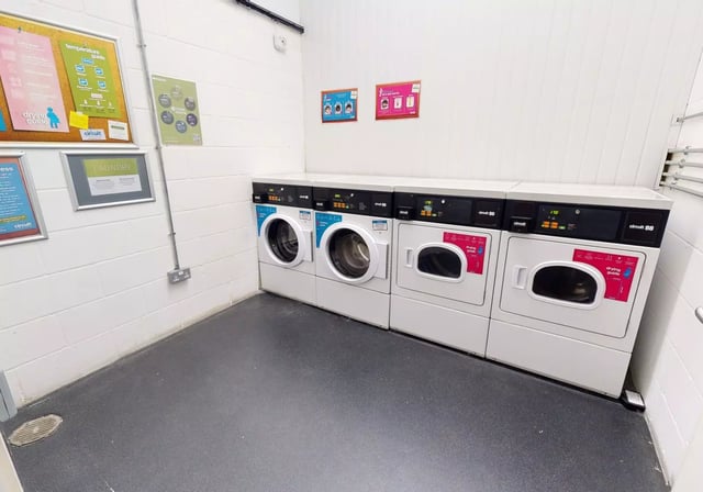 Row of washing machines and dryers laundry room at iQ Bankside in London Student Accommodation