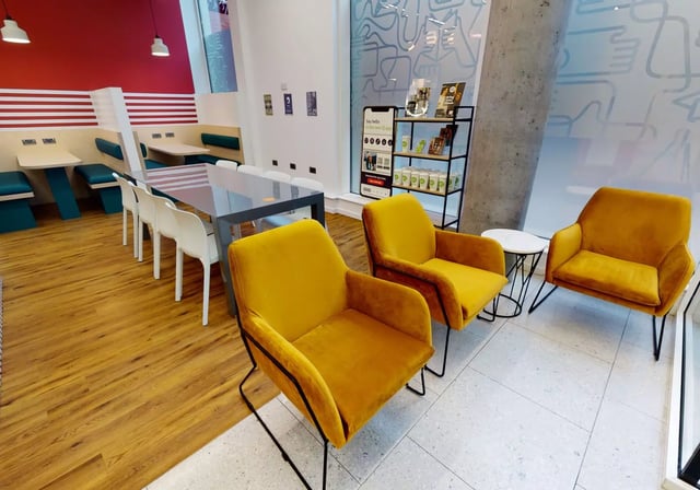 Yellow chairs dining tables white chairs living area at iQ Bankside in London Student Accommodation