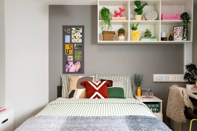 Bed with striped bedding pillows and photo collage Bedroom at East Central House in London Student Accommodation