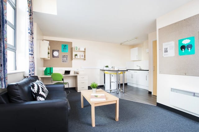 Black sofa desk kitchen and dining area living room at Magnet Court in Newcastle Upon Tyne Student Accommodation