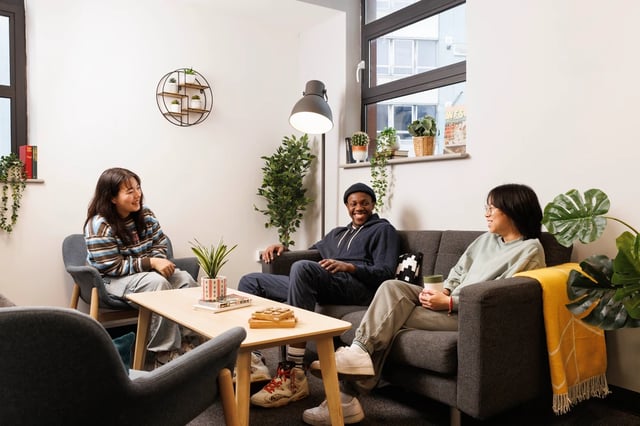 Three students relaxing on sofas living room at Magnet Court in Newcastle Upon Tyne Student Accommodation