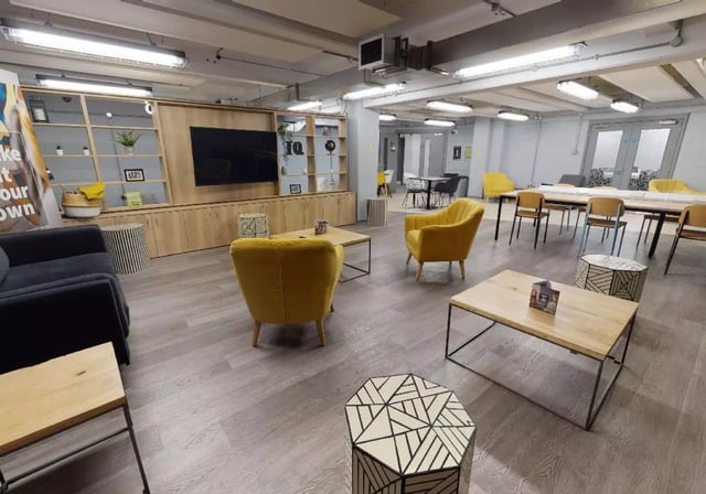 Living room with yellow chairs coffee tables at iQ Stephenson House in Newcastle Upon Tyne Student Accommodation