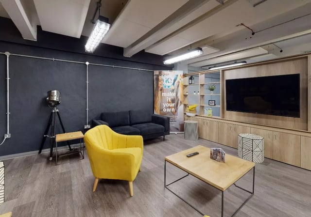 Sofa yellow chair coffee table TV living room at iQ Stephenson House in Newcastle Upon Tyne Student Accommodation