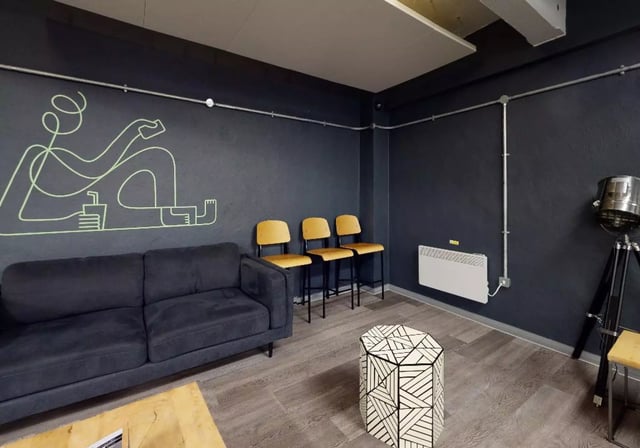 Dark sofa three chairs geometric table living room at iQ Stephenson House in Newcastle Upon Tyne Student Accommodation