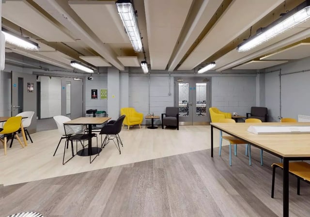 Tables chairs yellow and grey armchairs common area at iQ Stephenson House in Newcastle Upon Tyne Student Accommodation