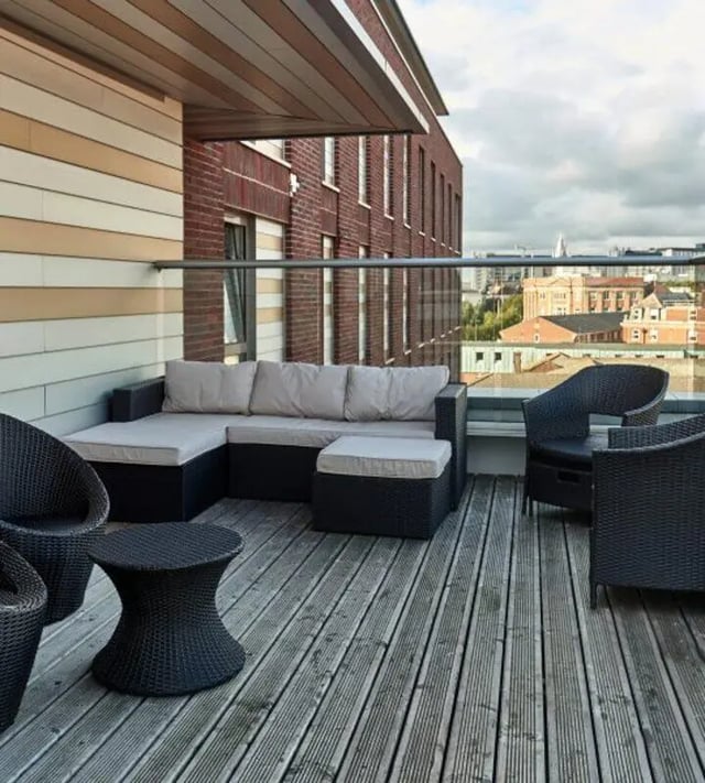 Outdoor lounge furniture on a balcony with cityscape balcony area at Hope Street in Liverpool Student Accommodation