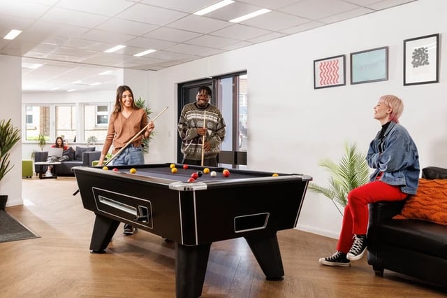 People playing pool on a black table recreation area at Leadmill Point in Sheffield Student Accommodation