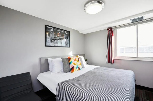 Bed pillows artwork window striped curtains bedroom at The Moor in Sheffield Student Accommodation